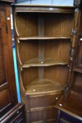 A modern mid stained Ercol corner shelf with cupboard to lower part