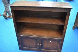 A vintage Priory or dark Ercol bookshelf with cupboard under
