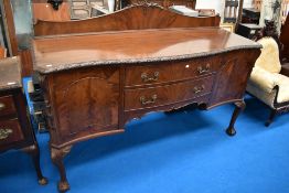 An early 20th Century mahogany sideboard having ledge back and carved border, width approx. 180cm