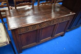A period oak kist having carved frieze and three panels to front, width approx. 115cm