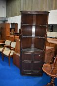 A vintage dark stained Ercol style corner shelf with cupboard under
