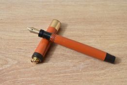 A Parker Lady Duofold Lucky Curve button fill fountain pen in red with broad band to a ring cap