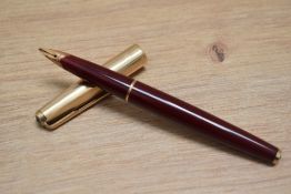 A Parker 65 aero fill fountain pen in burgundy with rolled gold cap having Parker 14k nib