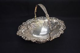 A Victorian silver basket, of oval form with pierced and bead-moulded pivoted handle, over the