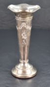 An Edwardian silver trumpet vase, with flared and ruffled rim over the tapering body embossed with