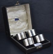 A cased set of four George V silver napkin rings, of plain cylindrical form with marks for