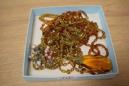 An assorted collection of amber coloured jewellery, including a large faceted pendant, and a white