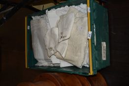 A box of assorted laced worked items, including table cloths