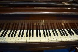 An early 20th Century mahogany cased baby grand piano by Steck having metal overstrung frame