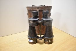 A pair of Bino Prismatic No5 MkIII X7 binoculars bearing the military crowsfoot mark in leather