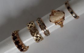 A 9ct yellow gold ring set with five round faced garnets,