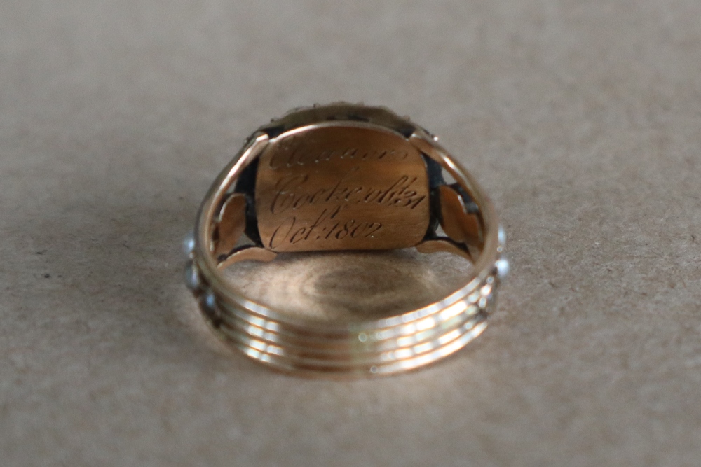 A late George III mourning ring set with a central oval faceted amethyst surrounded by half section - Image 4 of 6