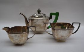 A white metal three piece tea set in the Art Deco style, decorated with geometric patterns,
