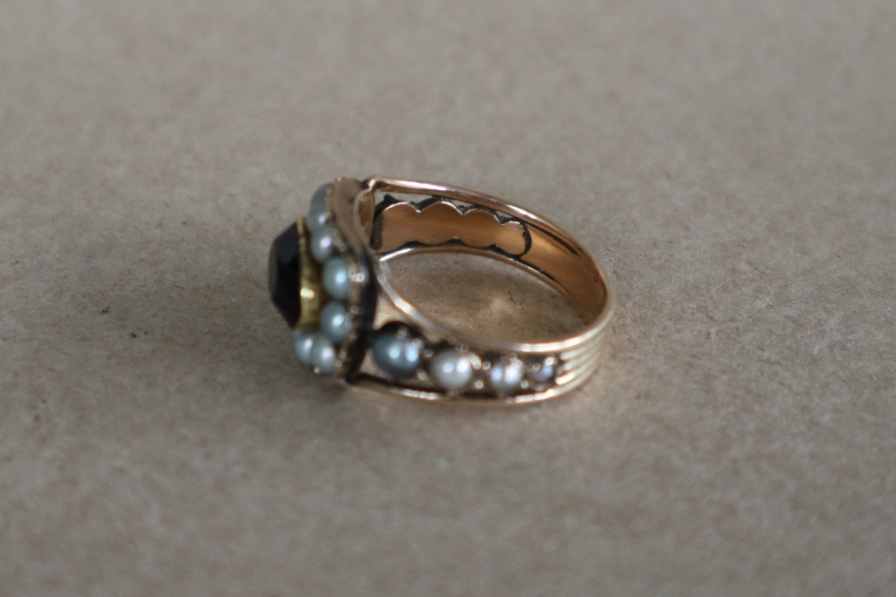 A late George III mourning ring set with a central oval faceted amethyst surrounded by half section - Image 5 of 6