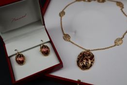 A Baccarat peach glass oval pendant in silver-gilt scrolled cage-work mount,