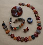 A banded agate brooch of circular form, 6cm diameter together with a banded agate necklace,