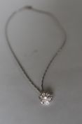An 18ct white gold diamond set pendant of floral form set with seven round brilliant cut diamonds