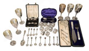 A collection of silver to include cased sets, napkin rings, and souvenir coffee spoons