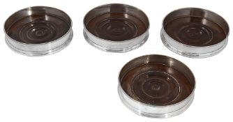 A set of four George III silver bottle coasters