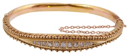 A diamond-set and yellow gold hinged bangle,
