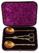 A silver gilt set of grape shears and serving spoons