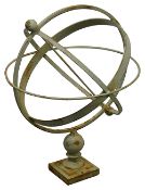 A pale green cast metal armillary sphere