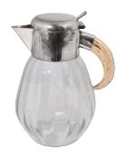 A German electroplate mounted glass lemonade jug with boar tusk handle