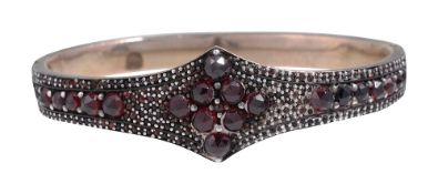 A mid 19th century garnet-set shaped hinged bangle