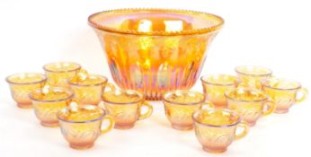 AN IRIDESCENT CARNIVAL GLASS PUNCH BOWL WITH TWELVE GLASSES