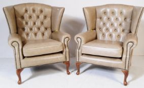 A PAIR OF BUTTON BACK LEATHER WING BACK ARMCHAIRS