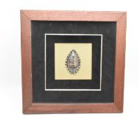 FRAMED WHITE METAL & ENAMEL TRIBAL MASK