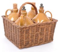 FOUR VICTORIAN STONEWARE FLAGONS IN WICKER CARRIER