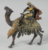 A COLD PAINTED BRONZE GROUP, man on a camel being attacked by a lion, 17 cm high.