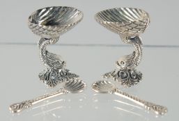 A PAIR OF SILVER DOLPHIN SALTS AND SPOONS.