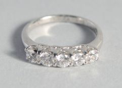 A SILVER CUBIC ZIRCONIA FIVE STONE RING.