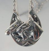 A HEAVY SILVER HORSE PENDANT AND CHAIN.