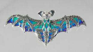 A SILVER ENAMEL AND RUBY EYE BAT BROOCH.