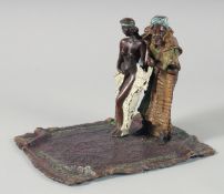 A GOOD COLD PAINTED BRONZE, ARAB AND SLAVE GIRL, on a carpet, 19 cm.