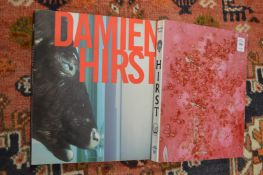 Two Damien Hirst books, both bearing a signature.