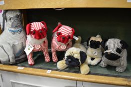 A collection of stuffed animals depicting pug dogs by Steiff and others.