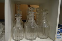 A pair of cut glass decanters and four others.