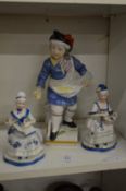 A Continental painted porcelain figure of a boy selling goods from his apron together with a pair of