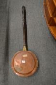 A copper bed warming pan.