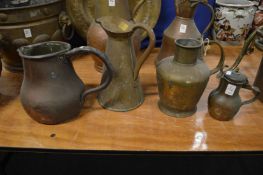 Four copper and brass jugs.