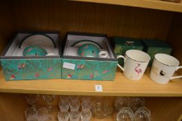A pair of boxed cups and saucers and a pair of boxed mugs.