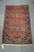 A small Persian rug, rust ground with stylised decoration (faults) 115cm x 75cm.