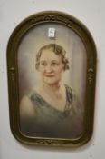 A pair of coloured photographic portrait prints in arched shaped frames with bowed glass.