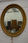 An oval gilt framed wall mirror.