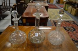 Three glass decanters and stoppers.
