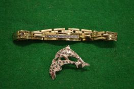 A silver brooch and a bracelet.